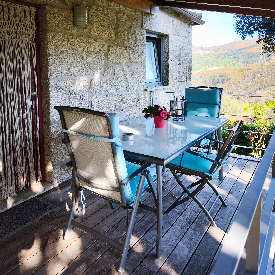 Terraço exterior com mobiliário de jardim e vista para a paisagem do Alto Minho
